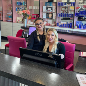 two women happily waiting to help at front desk